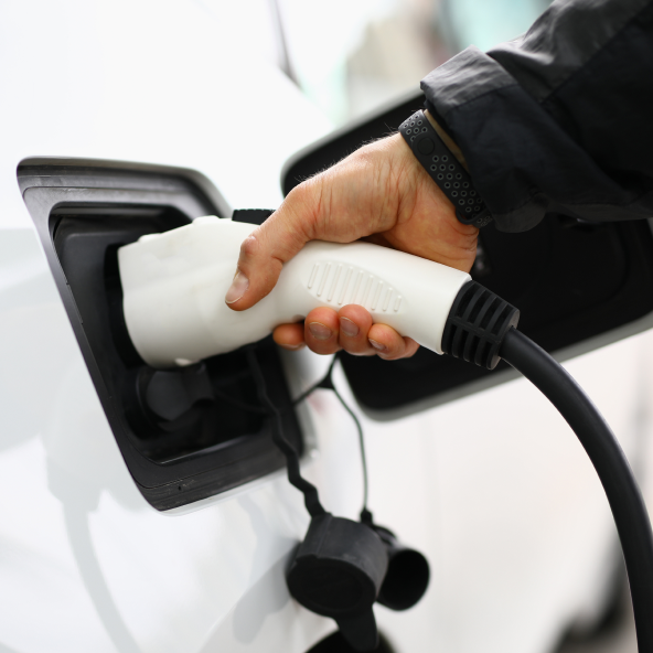 mężczyzna ładujący samochód elektryczny