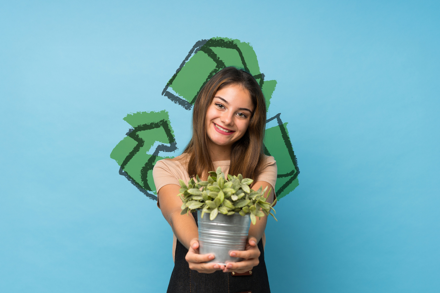 Eco event w M1 Czeladź. Dziewczyna trzymająca w rękach roślinkę, trzmielinę. Piktogram przedstawiający znak ekologii na drugim planie.