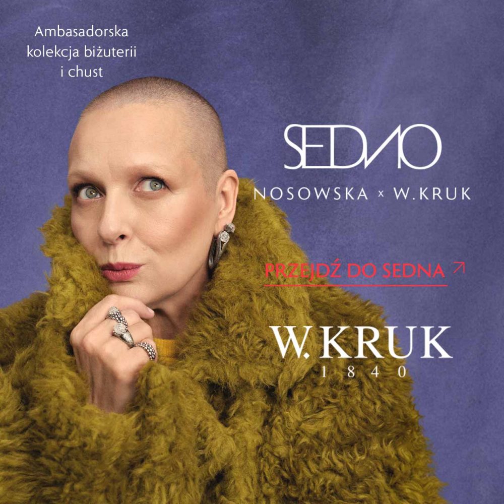 Katarzyna Nosowska w puszystym oliwkowym okryciu opiera dłoń pod brodą, prezentując pierścionki i kolczyki w srebrnym kolorze. Na fioletowym tle napisy „SEDNO NOSOWSKA x W.KRUK”, „Ambasadorska kolekcja biżuterii i chust”, „Przejdź do SEDNA” oraz logo W.KRUK.